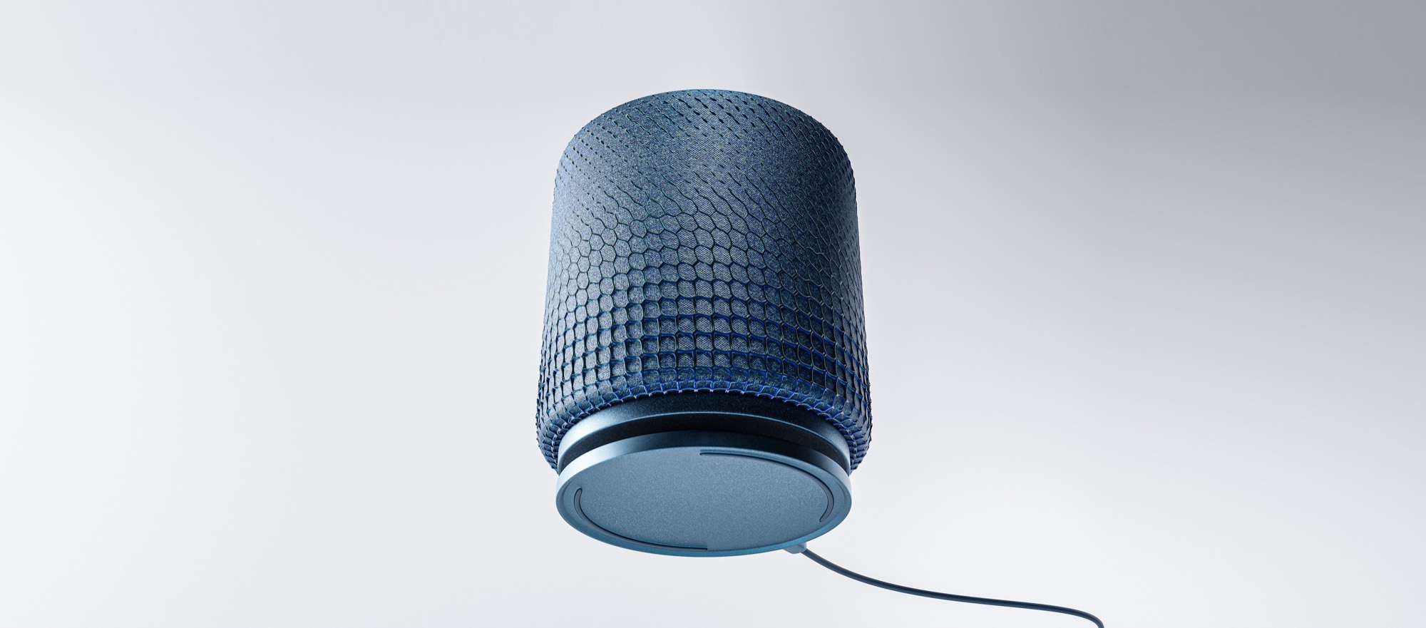 A blue ARC speaker lifting away from its circular charging base, the cable trailing off to the right