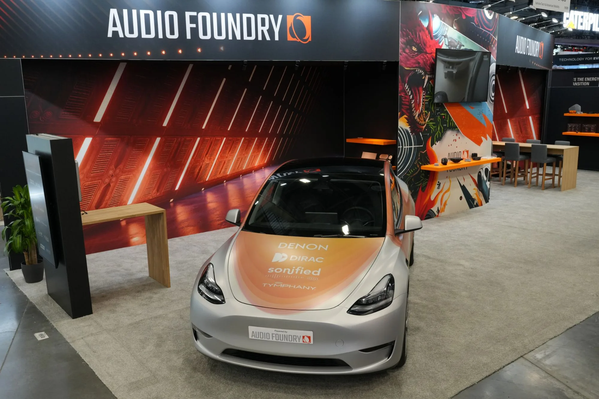 Front view of the demo car at the Audio Foundry booth, Denon, Dirac, Sonified and Tymphany marks on the bonnet