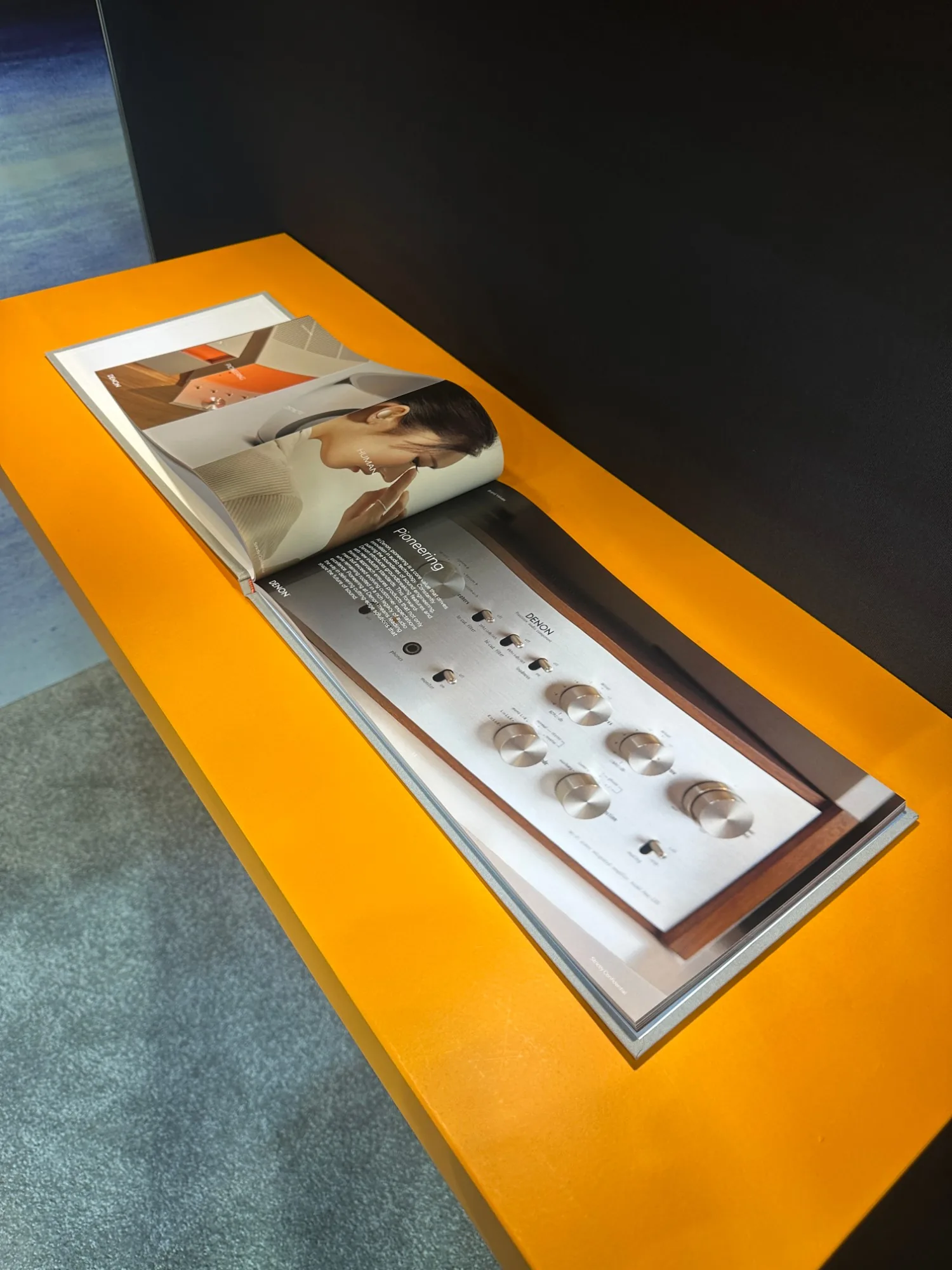 Denon brand book on display at the booth — the same visual language in print