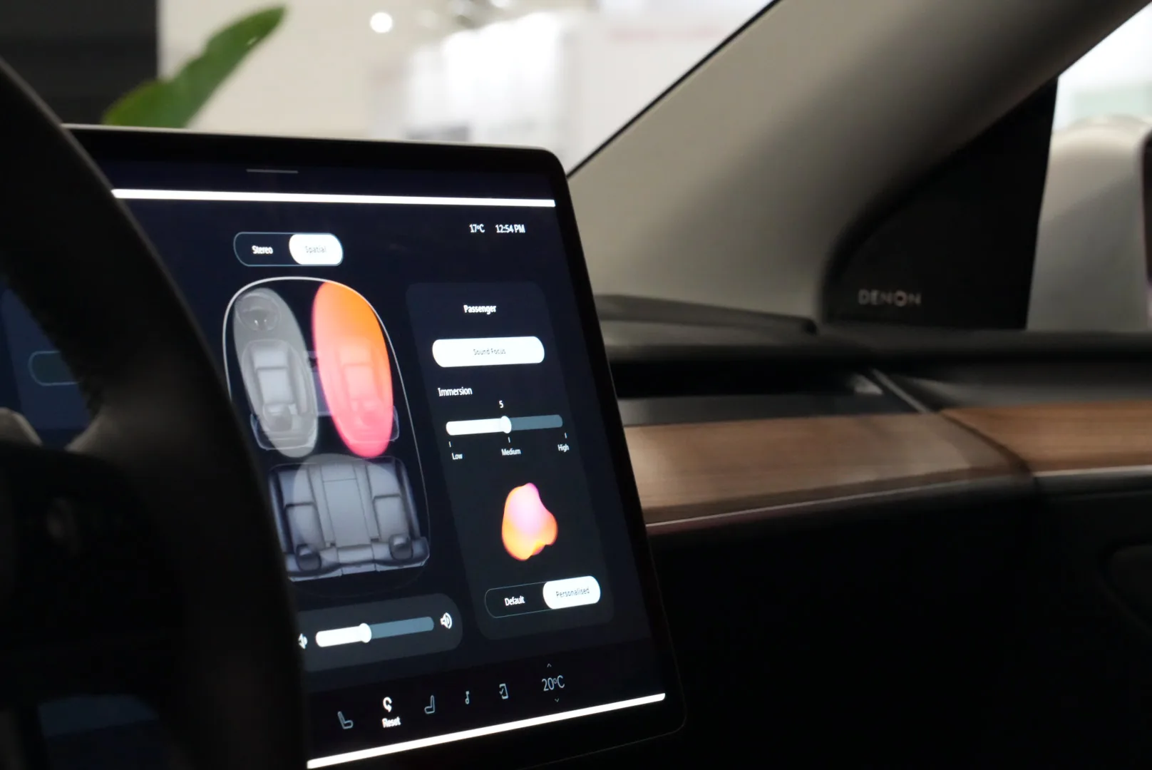 The Denon automotive interface running live on the Tesla's native display — spatial seat view, immersion slider and passenger Sound Focus